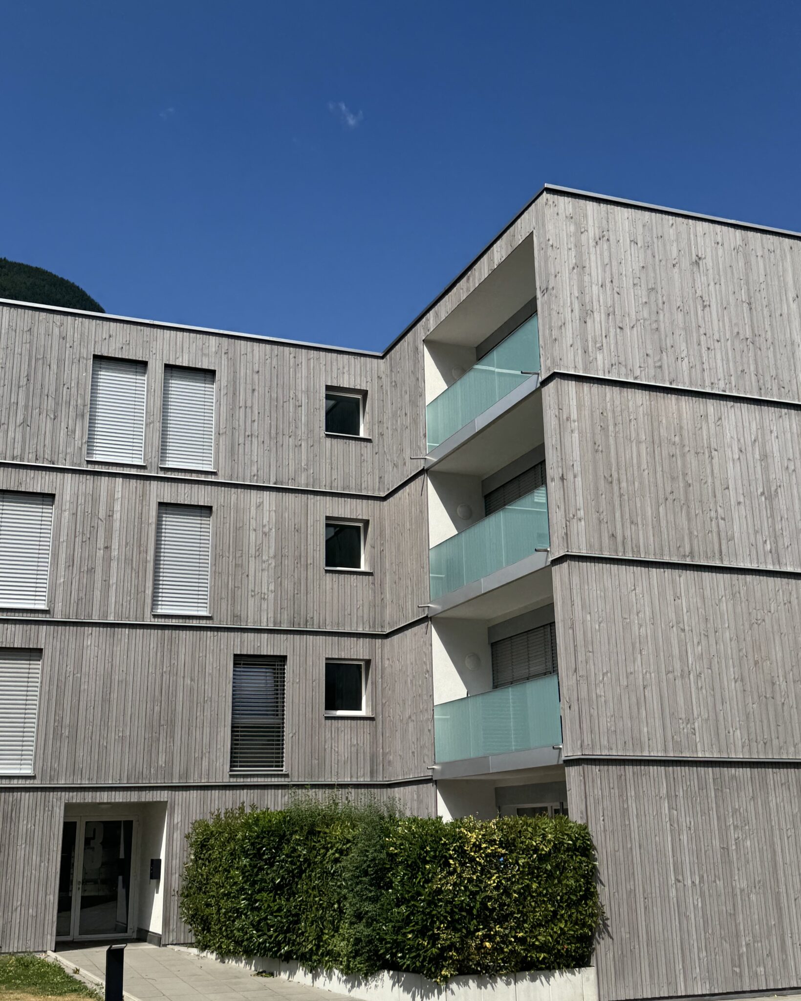 Ilettes 1-7 à Martigny, entrée de l'immeuble et balcons aux garde-corps vitrés